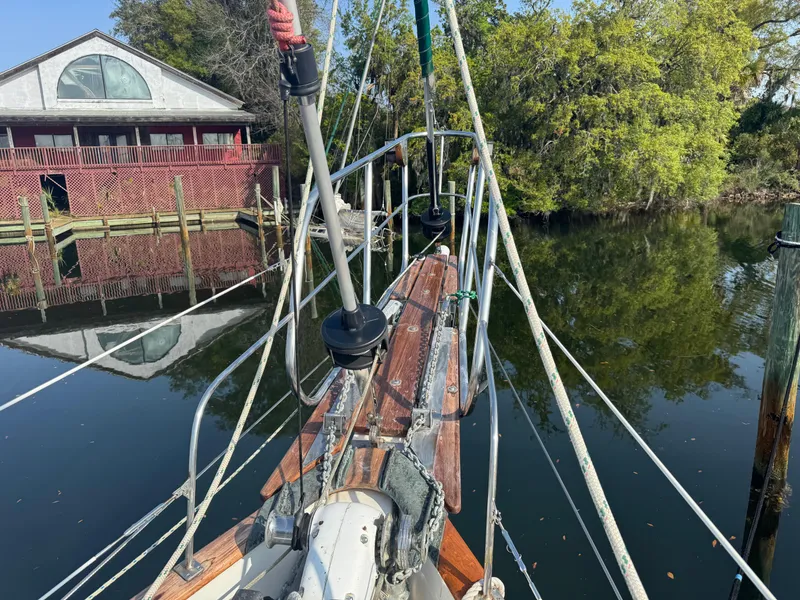 Slide: The Image of Bow of 1989 Hans Christian 43T sailboat docked near a brick building and trees. - 20