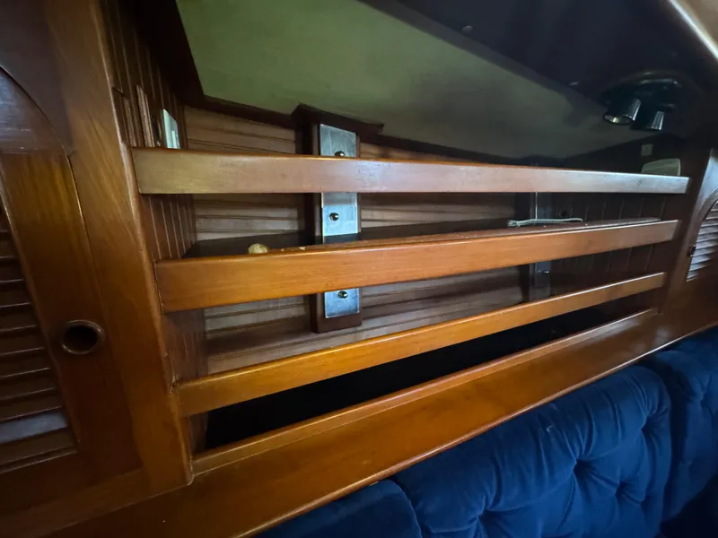 Slide: The Image of Interior of 1989 Hans Christian 43T sailboat, featuring wooden cabinetry and blue upholstery. - 43