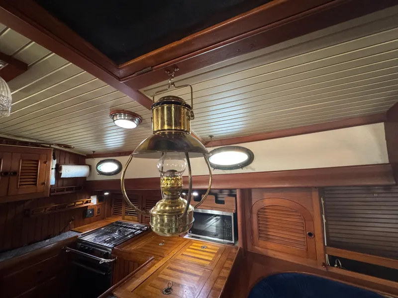 Slide: The Image of Interior of 1989 Hans Christian 43T sailboat with wooden cabinetry and vintage lantern. - 44