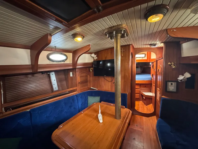 Slide: The Image of Interior of 1989 Hans Christian 43T sailboat with wooden furnishings and blue seating. - 46