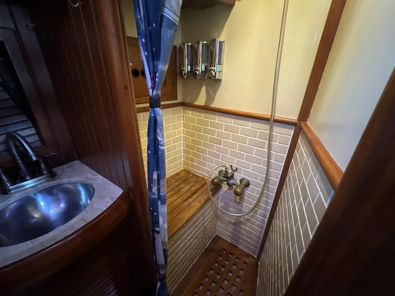 Slide: The Image of 1989 Hans Christian 43T yacht bathroom with wooden accents and tiled shower area. - 47
