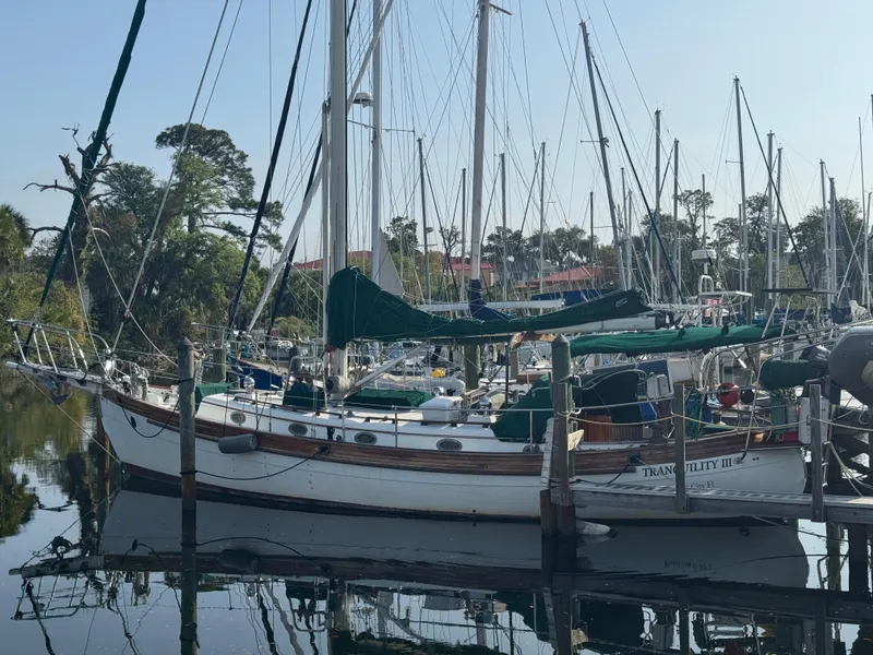 Slide: The Image of 1989 Hans Christian 43T sailboat docked in a marina, surrounded by other boats. - 6