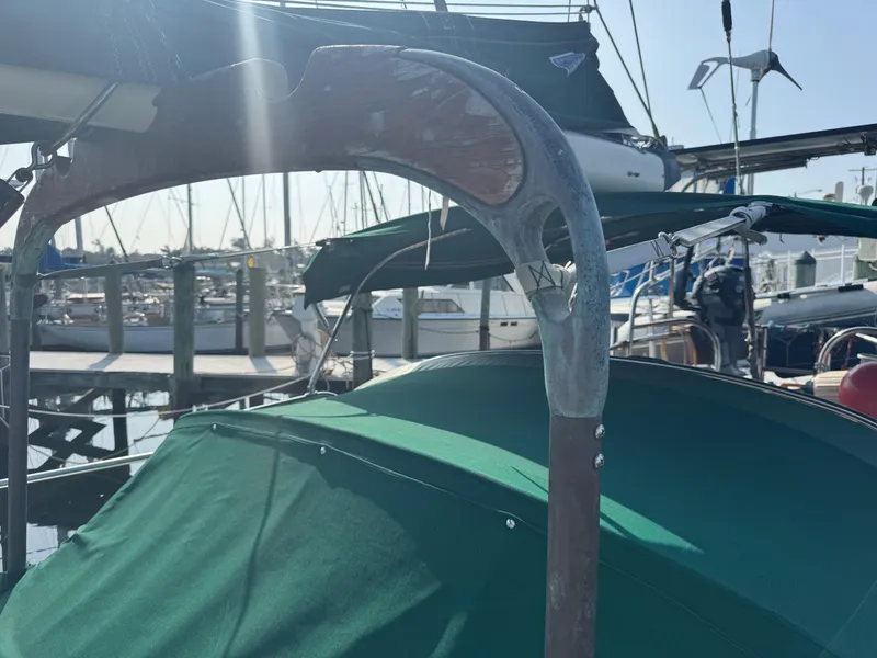 Slide: The Image of Sailboat docked at marina, featuring green canopy and metal frame, Hans Christian 43T, 1989 model. - 9