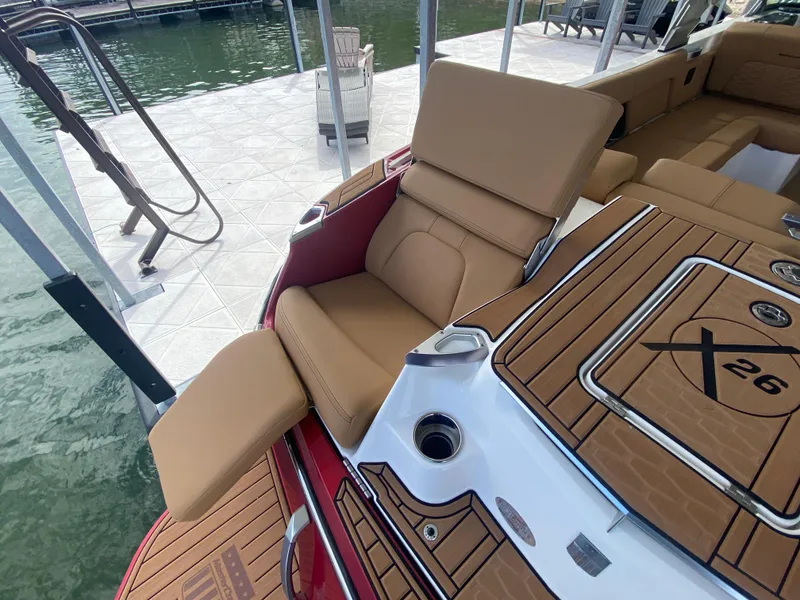 Slide: The Image of 2020 MasterCraft X26 boat with tan seating and teak-style decking at a dock. - 11