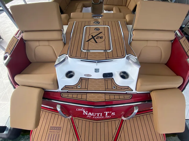 Slide: The Image of 2020 MasterCraft X26 boat interior with tan seating and wood accents. - 12