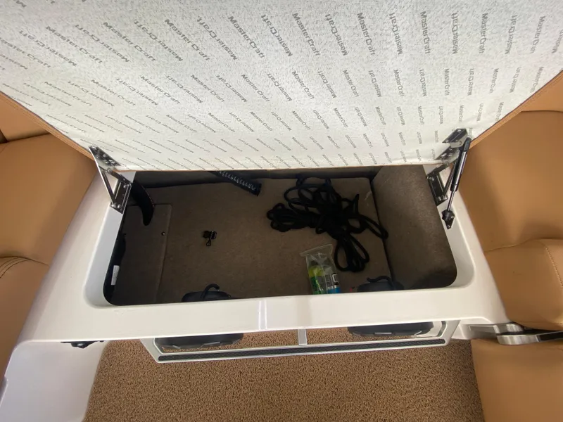 Slide: The Image of Open storage compartment in 2020 MasterCraft X26 boat with visible ropes and accessories. - 17