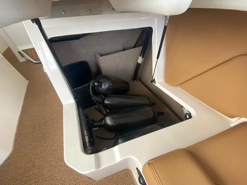 Slide: The Image of 2020 MasterCraft X26 storage compartment with black fenders and tan seating. - 18