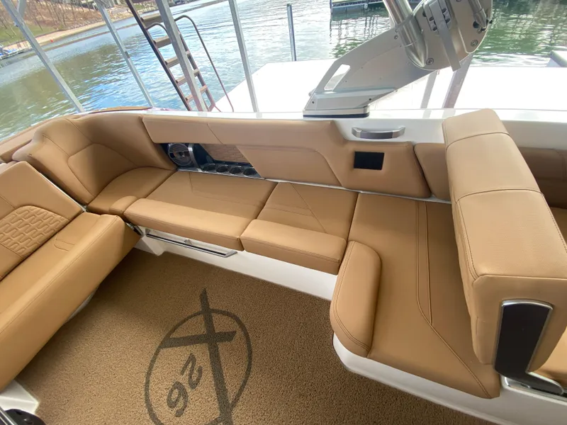 Slide: The Image of 2020 MasterCraft X26 boat interior with tan seating and lake view. - 20