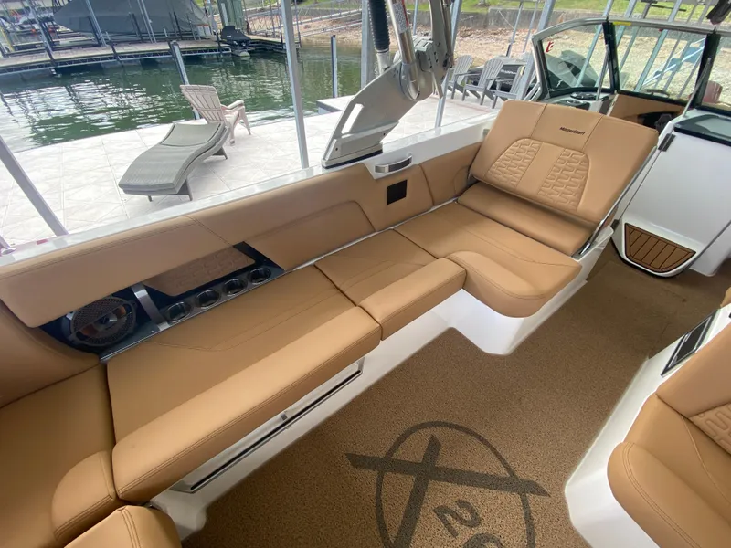 Slide: The Image of 2020 MasterCraft X26 boat interior with tan seating and lake view. - 22