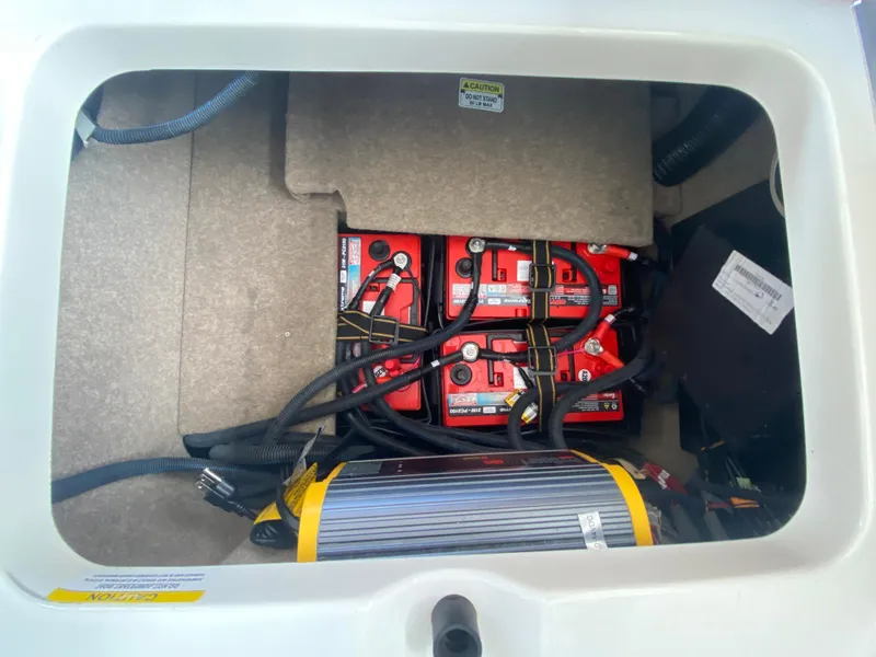 Slide: The Image of Battery compartment of a 2020 MasterCraft X26 boat, featuring multiple red batteries and wiring. - 25