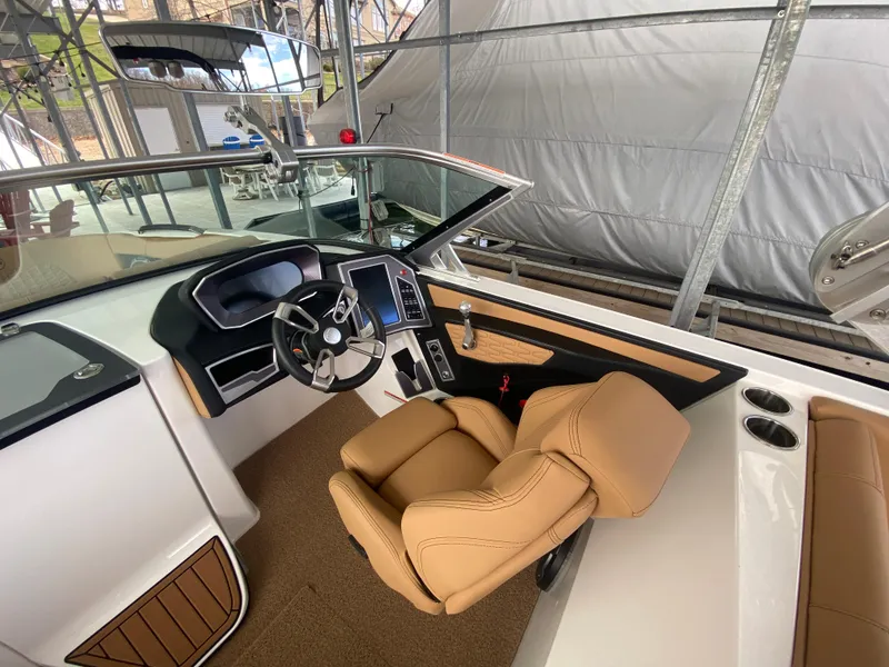 Slide: The Image of 2020 MasterCraft X26 boat interior with tan seating and modern dashboard. - 26