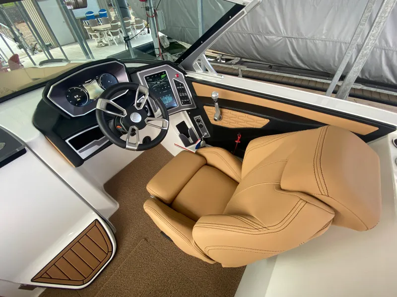 Slide: The Image of 2020 MasterCraft X26 boat interior with tan leather seat and modern dashboard controls. - 32
