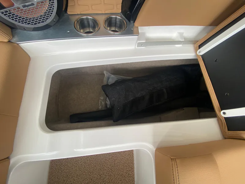 Slide: The Image of 2020 MasterCraft X26 boat interior storage compartment with beige seating and cup holders. - 42