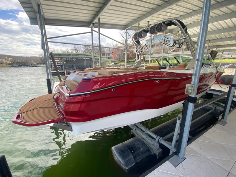 Slide: The Image of 2020 MasterCraft X26 boat in red, docked under a covered marina. - 5