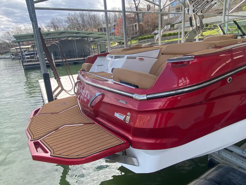 Slide: The Image of 2020 MasterCraft X26 boat with red exterior and tan seating at a dock. - 6