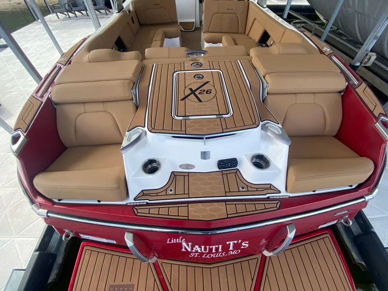 Slide: The Image of 2020 MasterCraft X26 boat interior with tan seating and wood accents. - 7