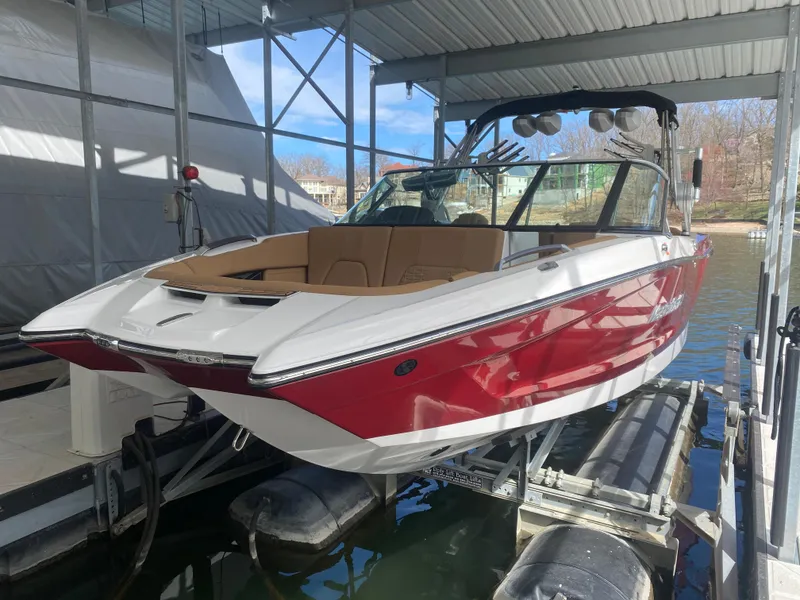Slide: The Image of 2020 MasterCraft X26 boat in red and white, docked in a covered marina. - 8