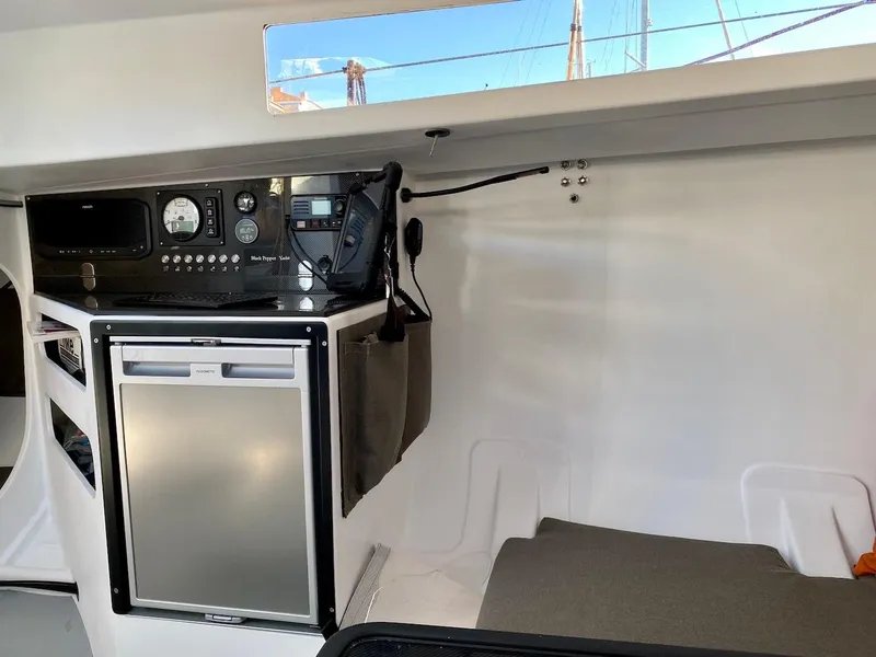 Slide: The Image of Interior of Black Pepper Code 0.1 yacht, featuring navigation equipment and compact fridge, 2025 model. - 20