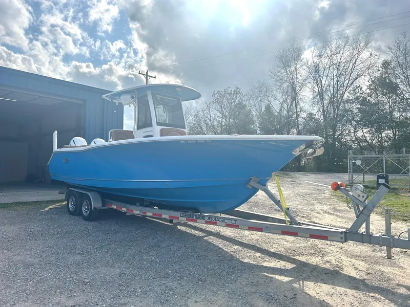Slide: The Image of 2020 Sea Hunt Ultra 275 SE boat on trailer, parked outdoors under cloudy sky. - 2
