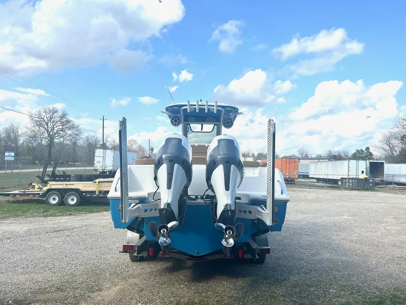 Slide: The Image of 2020 Sea Hunt Ultra 275 SE boat with dual engines, parked outdoors under a blue sky. - 4