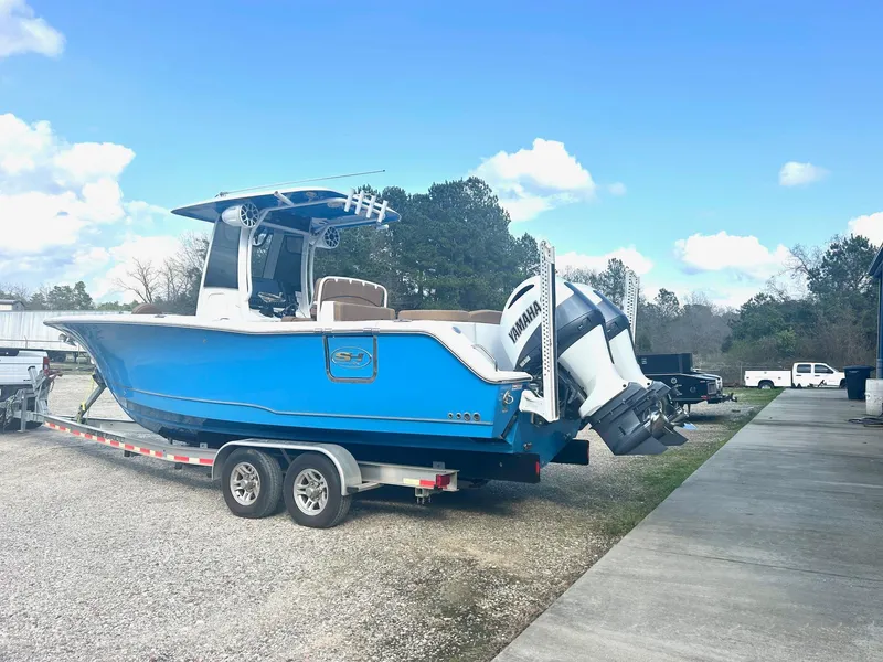 Slide: The Image of 2020 Sea Hunt Ultra 275 SE boat on trailer, blue hull, dual engines, outdoor setting. - 5