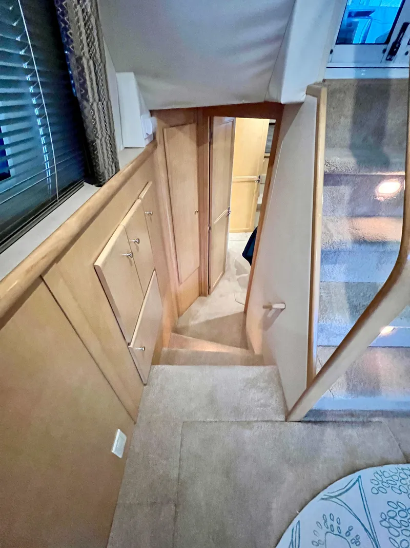 Slide: The Image of Interior of 1998 Carver 405 Aft Cabin yacht, featuring stairs and wooden cabinetry. - 13