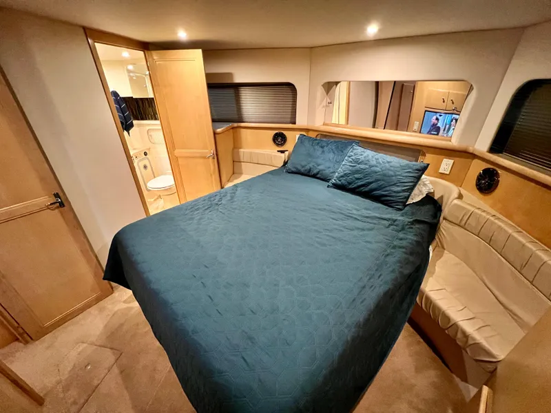 Slide: The Image of 1998 Carver 405 Aft Cabin interior with bed, bathroom, and wood accents. - 15