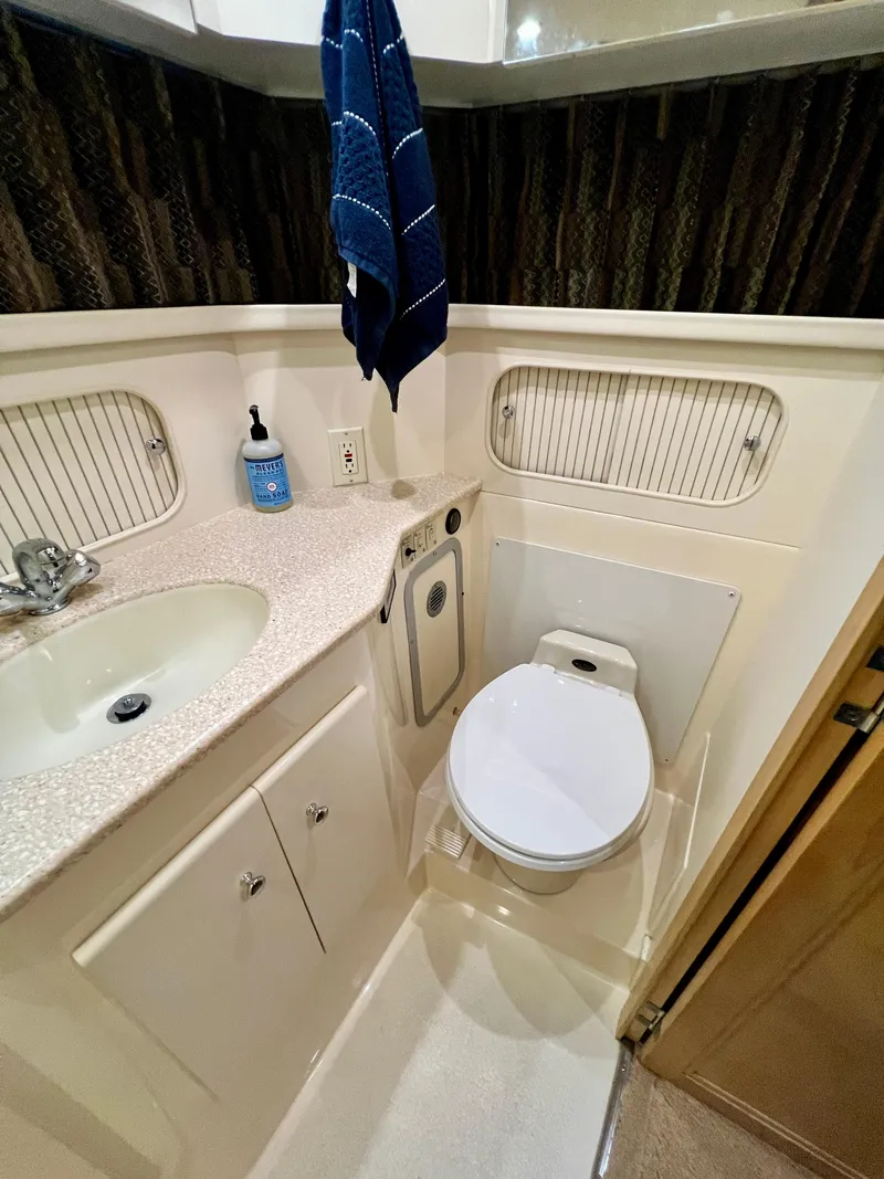 Slide: The Image of 1998 Carver 405 Aft Cabin bathroom with sink, toilet, and towel. - 18