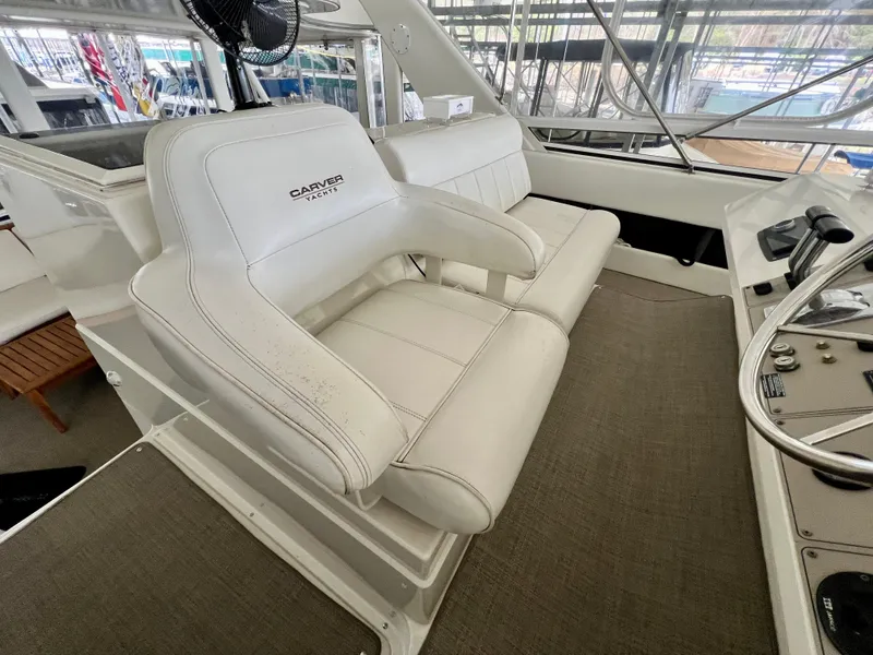 Slide: The Image of 1998 Carver 405 Aft Cabin yacht interior with white leather seating and control panel. - 25