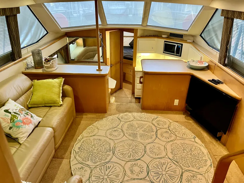 Slide: The Image of Interior of 1998 Carver 405 Aft Cabin with cozy seating, decor, and kitchenette. - 3