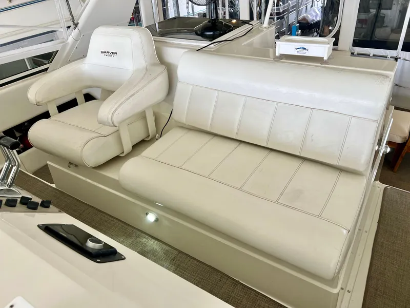Slide: The Image of 1998 Carver 405 Aft Cabin yacht interior with white seating and control panel. - 30