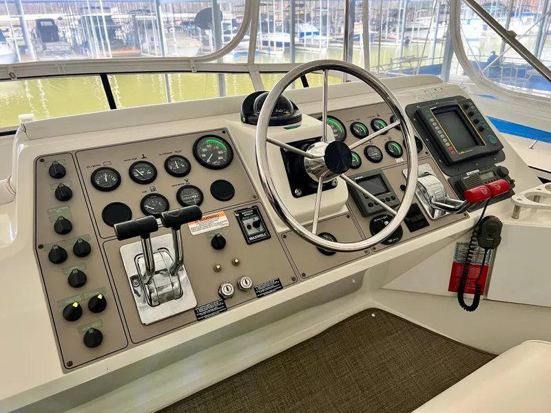 Slide: The Image of 1998 Carver 405 Aft Cabin helm with steering wheel, gauges, and controls. - 31