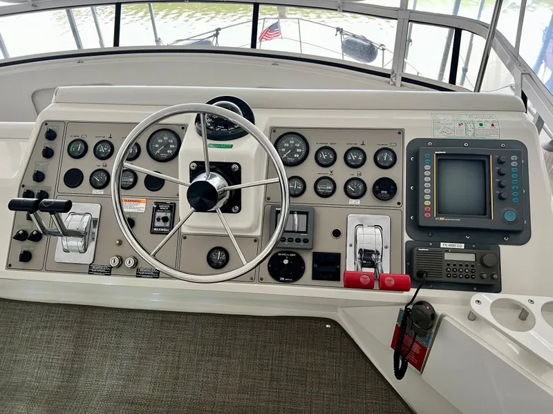 Slide: The Image of 1998 Carver 405 Aft Cabin helm with steering wheel, gauges, and navigation equipment. - 33