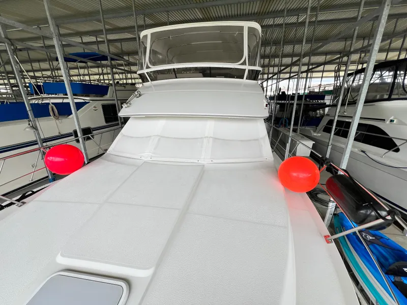 Slide: The Image of 1998 Carver 405 Aft Cabin yacht docked with red fenders in a marina. - 41