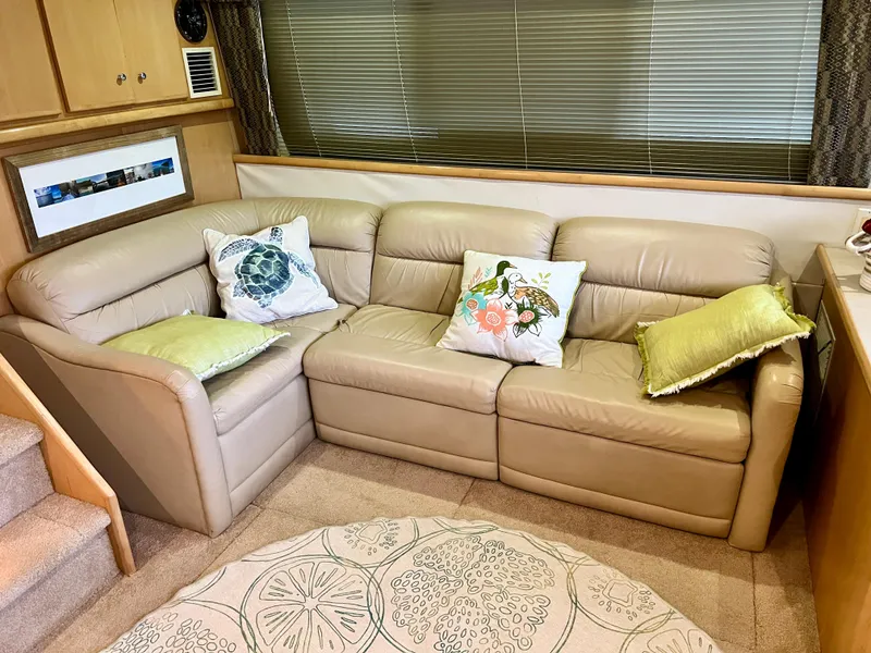 Slide: The Image of Luxurious beige leather sofa in 1998 Carver 405 Aft Cabin, adorned with decorative pillows. - 5