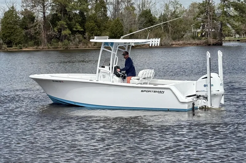 Slide: The Image of 2021 Sportsman Heritage 231 Center Console boat on a calm lake with trees in the background. - 13