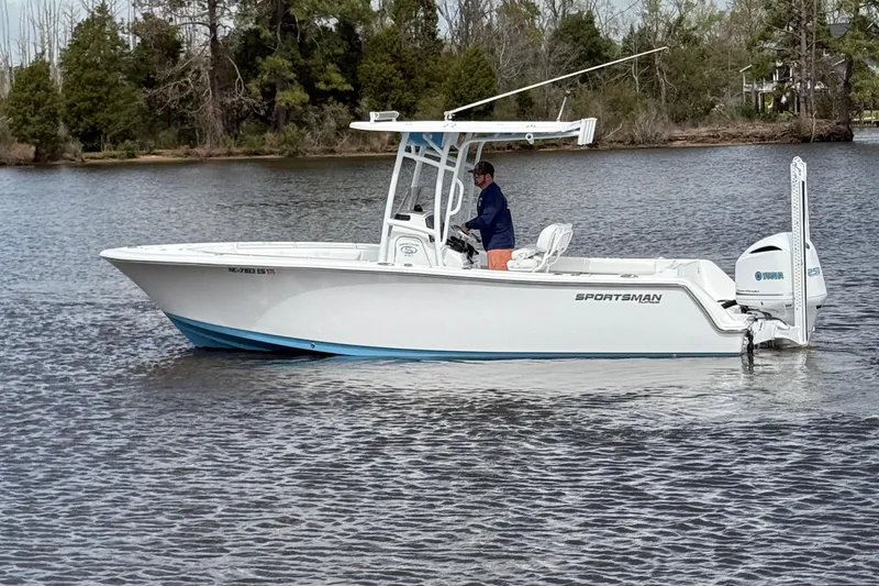 Slide: The Image of 2021 Sportsman Heritage 231 Center Console boat on calm water with trees in the background. - 14