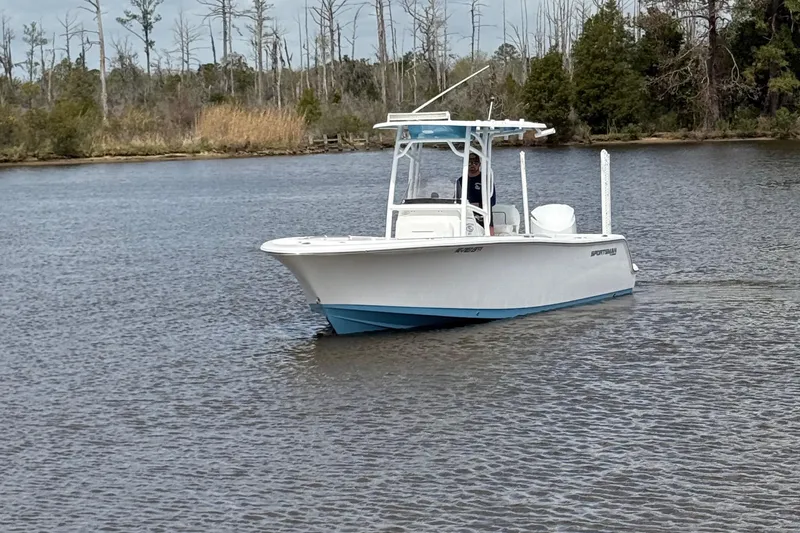Slide: The Image of 2021 Sportsman Heritage 231 Center Console boat on calm water, surrounded by trees. - 16