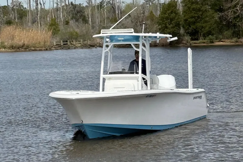 Slide: The Image of 2021 Sportsman Heritage 231 Center Console boat on calm water, surrounded by trees. - 17