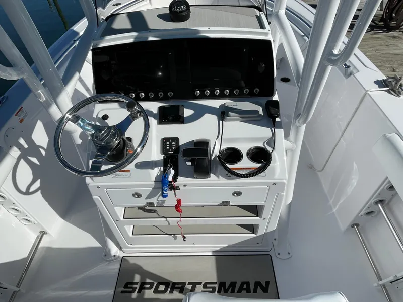 Slide: The Image of 2021 Sportsman Heritage 231 Center Console boat dashboard with steering wheel and controls. - 28