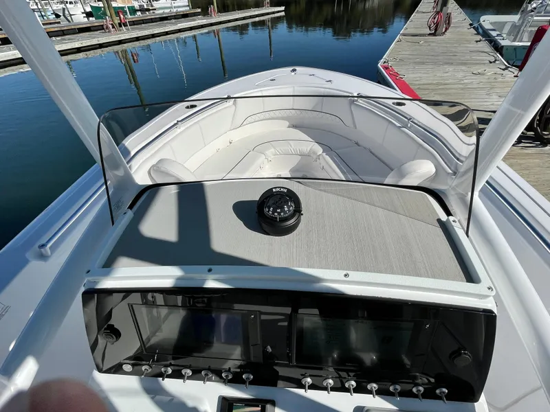 Slide: The Image of 2021 Sportsman Heritage 231 Center Console boat interior with dashboard and seating, docked at marina. - 35