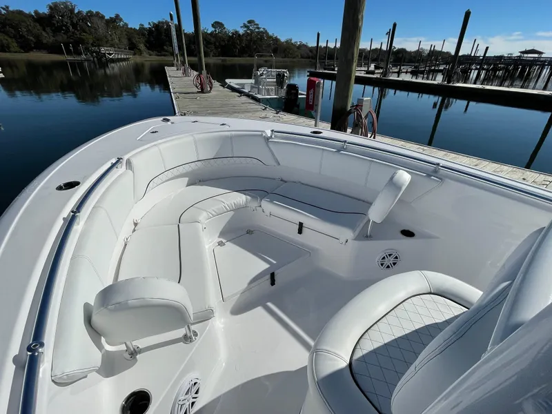 Slide: The Image of 2021 Sportsman Heritage 231 Center Console boat with white seating, docked by a calm marina. - 39