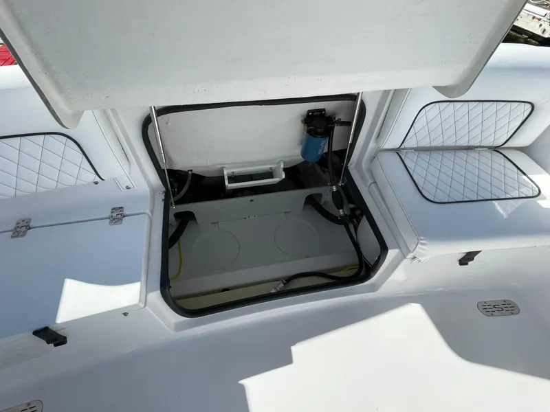 Slide: The Image of 2021 Sportsman Heritage 231 Center Console storage compartment with cushioned seating and open hatch. - 45