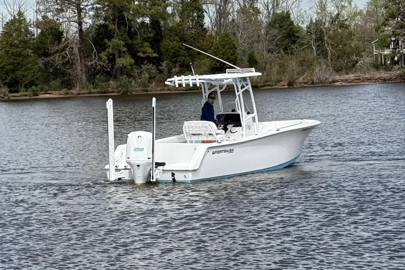 Slide: The Image of 2021 Sportsman Heritage 231 Center Console boat on a calm lake with trees in the background. - 8