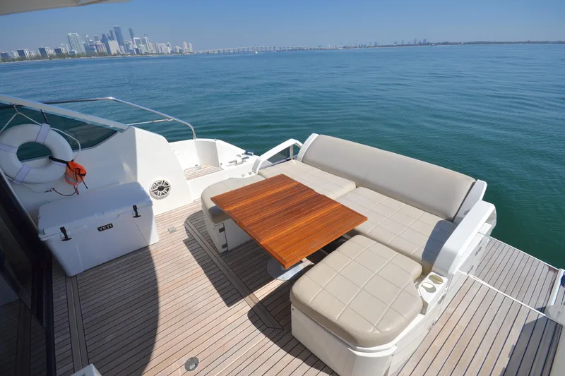 Slide: The Image of 2013 Fairline Targa 50 GT yacht deck with seating and table, overlooking city skyline. - 13