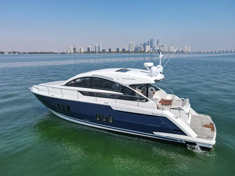Slide: The Image of 2013 Fairline Targa 50 GT yacht cruising on calm waters with city skyline backdrop. - 4
