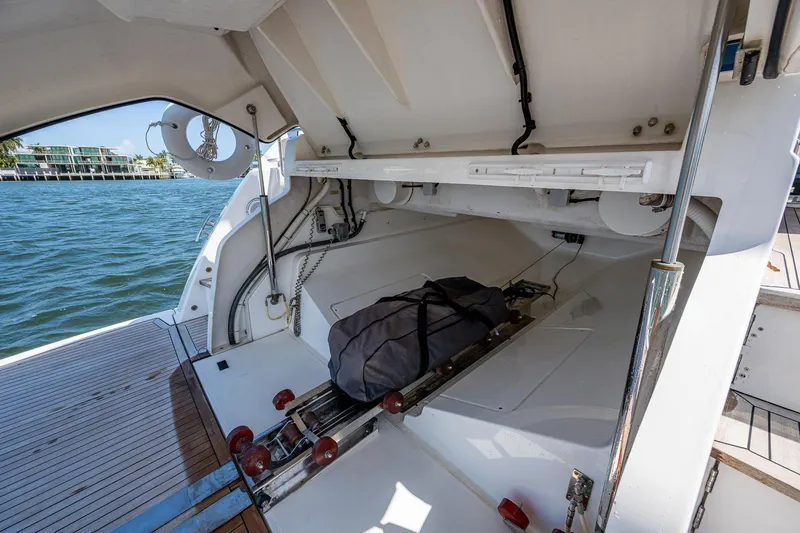 Slide: The Image of 2019 Sunseeker Predator 50 yacht storage compartment with open hatch, docked by the water. - 11