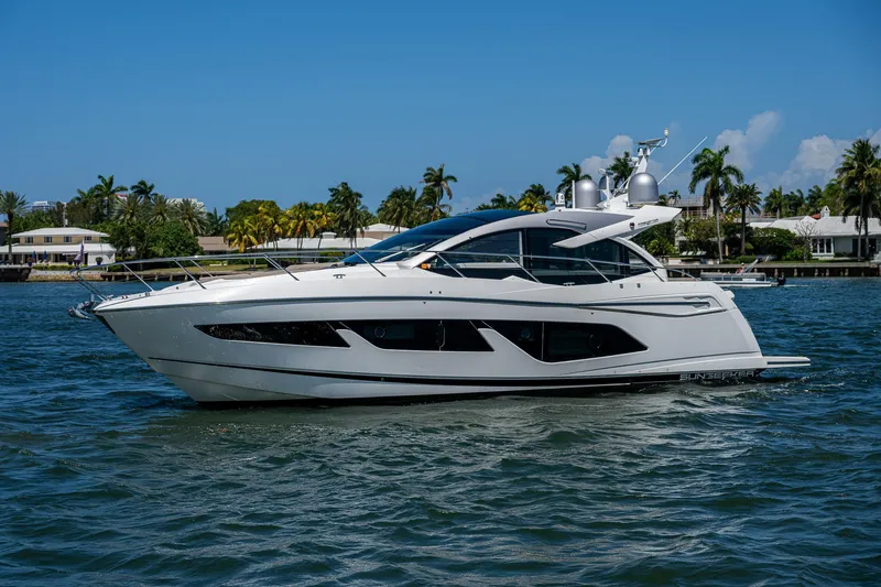 Slide: The Image of 2019 Sunseeker Predator 50 yacht cruising on a sunny day with palm trees in the background. - 3