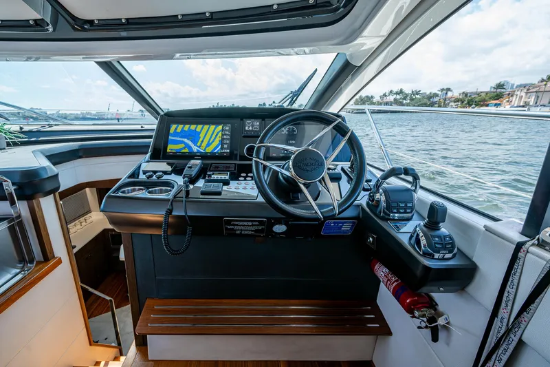 Slide: The Image of 2019 Sunseeker Predator 50 yacht helm with navigation controls and waterfront view. - 36