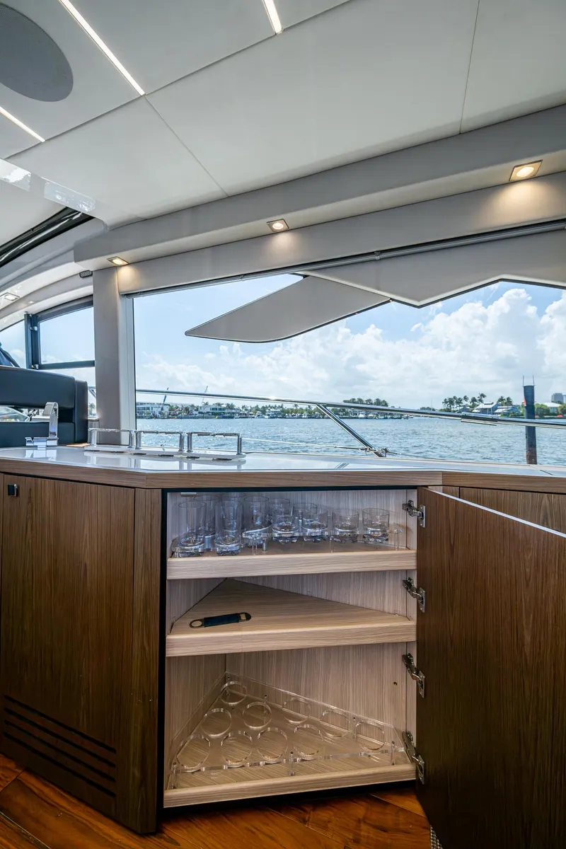 Slide: The Image of 2019 Sunseeker Predator 50 yacht interior with open cabinet and ocean view. - 38